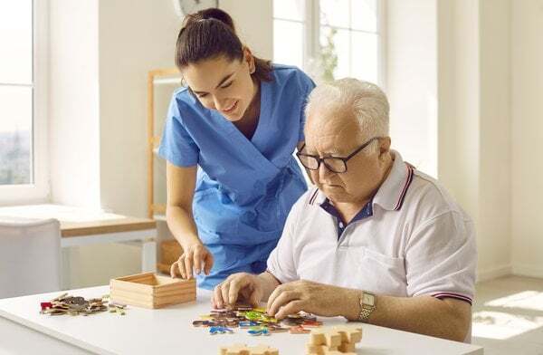 dementia-caregiver-assisting-elderly-man-puzzle-4